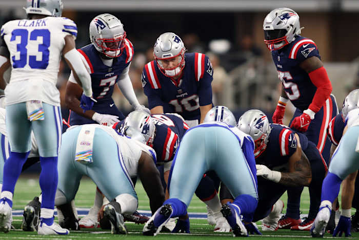 New England Patriots quarterback Mac Jones (10) attempts to rush for a first down in the second quarter against the Dallas Cowboys at AT&T Stadium.